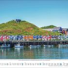 Kalendarische Daten für September, darunter farbige Häuserreihe am Hafen, grüne Hügel und Boote im Wasser.