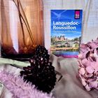 Reiseführer „Languedoc-Roussillon: Okzitanien entdecken“, umgeben von einem braunen Glasgefäß und rosa Hortensien.