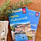 „CityTrip Dubrovnik“ Reiseführer, hellblaues Cover, Foto von Dubrovniks Altstadt mit Meer, Topfpflanze links.