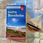 "Insel|Trip Bornholm", eine Karte mit einem Modellsegelboot und einem Bild von Strand und Meer bei klarem Himmel.