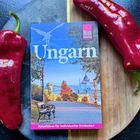„Ungarn“, „Reiseführer für individuelles Entdecken“. Bild mit Parkbank, Herbstbäumen, Blick auf Parlament. Rote Paprika.