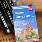 Reiseführer „CityTrip Barcelona“ mit Foto der Sagrada Família. Links Bücher über Gaudí.