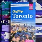 Stadtführer "CityTrip Toronto" mit einem Stadtbild und farbigem Hintergrundmuster in Blau und Weiß.