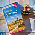 "Insel|Trip Ameland" Reiseführer auf Karte. Nebenbei eine kleine Strand-Dekoration.