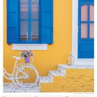 FEBRUAR 05. Woche 2027. Gelbe Wand, blaues Fenster, weißes Fahrrad mit Blumen, Treppe.