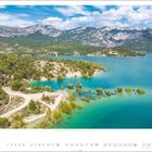 Ein Kalenderblatt zeigt eine Landschaft mit türkisfarbenem Wasser, bewaldeten Ufern und Bergen im Hintergrund. Unten sind Zahlen von 1 bis 30 angeordnet, und darüber steht "9".