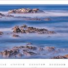 Kalenderseite, Zahlen 1 bis 30 unten. Nebelige Küstenszene mit Felsen im Meer. Dezente Farben, ruhige Atmosphäre.