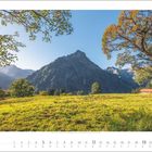 Kalender: "9 2027". Eine malerische Herbstlandschaft mit Bergen, grünen Wiesen und einem großen Baum.