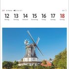 Juli: Montag 12, Dienstag 13, bis Sonntag 18. Borgsumer Windmühle auf Föhr, umgeben von Bäumen vor blauem Himmel.