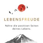 "LEBENSFREUDE. Nähre die positiven Seiten deines Lebens." Illustration: roter Kreis, schwarze Vögel, grauer Berg.