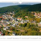 "Schneeberg aus der Luftperspektive. September. Waldreiche Landschaft, dicht bebaute Stadt mit farbigen Dächern."