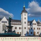 09, September. Ein historisches Gebäude mit Turm, davor ein Brunnen mit Statue, unter blauem Himmel mit Wolken.