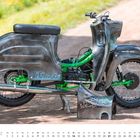 "Ur-Krostitzer" und "Production Ice-Design" auf chromfarbenem Moped mit grünem Rahmen; Kalender für März darunter.