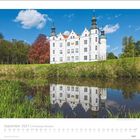 „September 2027 | Schleswig-Holstein“. Ein weißes Schloss mit Türmen spiegelt sich in einem ruhigen Gewässer, umgeben von Bäumen.