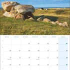 Septemberkalender 2027, Bild eines Steinzeitgrabes auf einer Wiese, im Hintergrund Häuser und Meer.