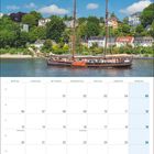 Kalender für September 2027. Enthält Feiertage. Bild: Segelboot auf Fluss vor Hügel mit Häusern und Bäumen.