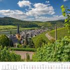 Kalenderseite für September 2027 mit einem Dorf, Fluss, Hügeln und Weinfeldern unter einem blauen Himmel.