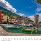 Kalenderblatt September 2027. Boote im Hafen vor bunten Gebäuden und Bergen. Ein rustikaler Turm am Wasser.