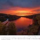 Kalenderblatt September 2027. Landschaft mit leuchtendem Sonnenaufgang über einem Fluss, umgeben von Bäumen.