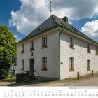 Kalender für September 2027 mit einem alten weißen Gebäude und Bäumen unter einem bewölkten Himmel.