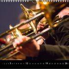 Kalenderblatt mit hervorgehobenen Daten, darunter spielende Musiker mit Blechblasinstrumenten.