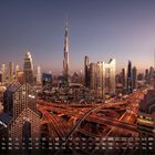 Kalender mit den Tagen des Monats. Skyline von Dubai in der Dämmerung, Burj Khalifa in der Mitte, beleuchtete Autobahnen.