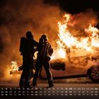 Kalender mit September-Daten unten. Zwei Feuerwehrleute bekämpfen einen brennenden Pkw bei Nacht.