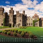 Kalenderansicht unten, „Ashford Castle“ rechts. Schloss mit Türmen, bewachsener Fassade, gepflegter Garten, blauer Himmel.