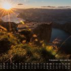 Kalender: Preikestolen – Blick über den Lysefjord. Sonnenuntergang über Felsen und Wasser, leuchtende Sonne.