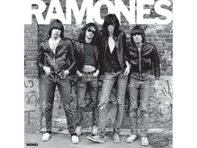 "RAMONES" oben, "MONO" unten. Vier Menschen in Lederjacken stehen vor einer Ziegelwand, lässige Haltung.