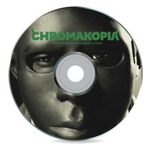 „CHROMAKOPIA“ in Grün. Nahaufnahme eines maskierten Gesichts auf einer CD.