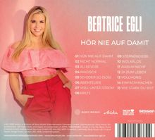 "BEATRICE EGLI - HÖR NIE AUF DAMIT" Album Titelliste mit 15 Liedern. Frau in pinker Bluse und roter Hose lächelt.