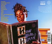 Texte: Liedtitel in gelber Schrift links, "How To Be Human" auf großem Buch. 

Frau mit lockigem Haar hält ein Buch unter blauem Himmel.