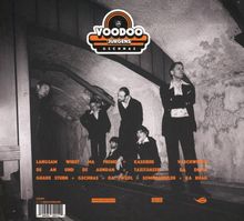 Logo mit „VOODOO JÜRGENS GSCHNAS“. Männer in Anzügen in einem rauen, niedrigen Gewölbe.