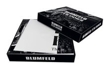 Schwarzer Karton mit "BLUMFELD FÜR IMMER" bedruckt. Darin eine Box mit Konzertbild und weißem Heft sichtbar.