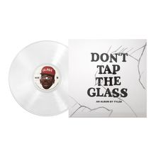 Text: "DON'T TAP THE GLASS, AN ALBUM BY TYLER." Eine transparente Schallplatte mit dem Bild einer Person mit roter Mütze.