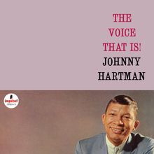 "The Voice That Is! Johnny Hartman" in roten und schwarzen Buchstaben; lächelnder Mann im Anzug darunter.