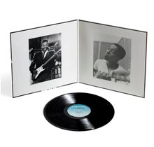 Die Schallplatte hat ein blaues Label mit schwarzem Text. Links ein Schwarzweiß-Foto von einem Mann mit Gitarre.