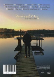 "Reinhard Mey - Schatzhauser" in hellem Schriftzug, darunter vierzehn Titelnummern. Ein Mann auf einem Steg bei Sonnenuntergang.