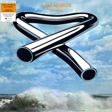 "Tubular Bells, Mike Oldfield" in orange Schrift. Illustration von verdrehten, metallischen Röhren vor einem welligen Meer.