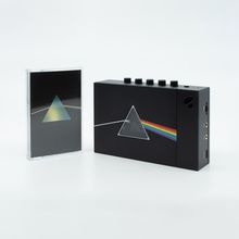 Links: Kassette mit Prisma-Motiv. Rechts: Schwarzes Gerät mit derselben Illustration, Regenbogen-Effekt.