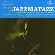 „an experimental fusion of hip-hop and jazz JAZZMATAZZ“. Mann mit Mikrofon, umgeben von Rauch in dunkler Umgebung.