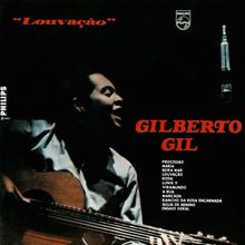 "GILBERTO GIL" in Rot. Liederliste darunter. Sänger mit Gitarre links, ein Mikrofon rechts, dunkler Hintergrund.