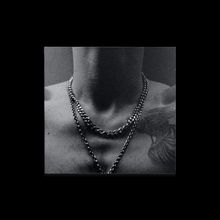 Ein dunkler Hintergrund mit einem Hals, der mehrere Ketten trägt. Keine Texte vorhanden.