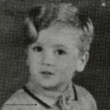 Text: "JOHN LENNON/PLASTIC ONO BAND". Eine verpixelte Schwarz-Weiß-Fotografie eines kleinen Kindes.