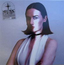 Text: "MEG MAC IT'S MY PARTY". Eine Frau mit dunklem Haar und schwarzem Halsband. Elegantes, ärmelloses Outfit.