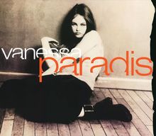 „Vanessa Paradis“ in großer, stilisierter Schrift. Ein schwarz-weißes Foto von einer Frau auf einem Holzfußboden.