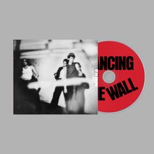 Auf der CD steht „DANCING THE WALL“. Ein verschwommenes Schwarz-Weiß-Foto zeigt drei Personen in lässiger Pose.