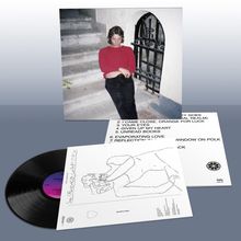 Eine Schallplatte und ein Cover mit einem Tracklisting und einer Zeichnung. Eine Person sitzt auf Treppen in rotem Pullover.