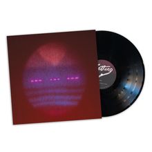 Der Text "Fitting" steht auf dem Etikett einer schwarzen Vinyl-Schallplatte. Ein verschwommener Lichtkreis ziert das Cover.